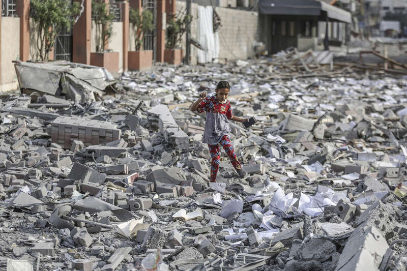 一名巴勒斯坦女孩走在被毁建筑的废墟中