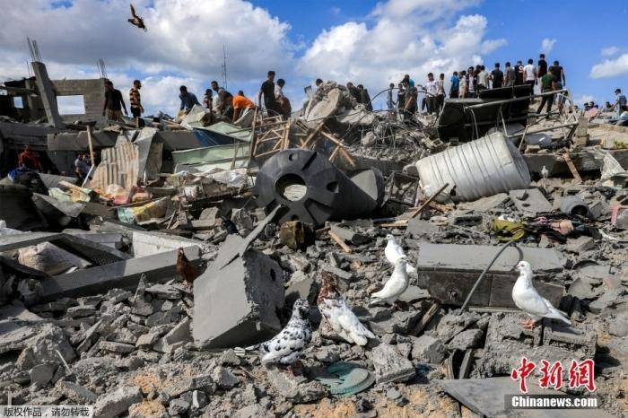 汗尤尼斯被以色列轰炸后，人们检查被毁建筑的残骸
